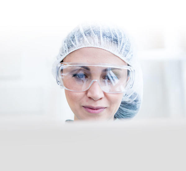 A researcher woking on a laptop in a laboratory.